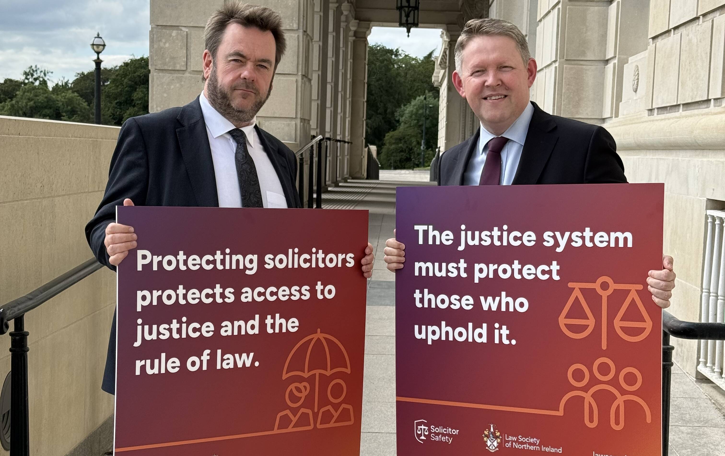 Eoghan McKenna holds a Solicitor Safety poster prior to an appearance before the Justice Committee
