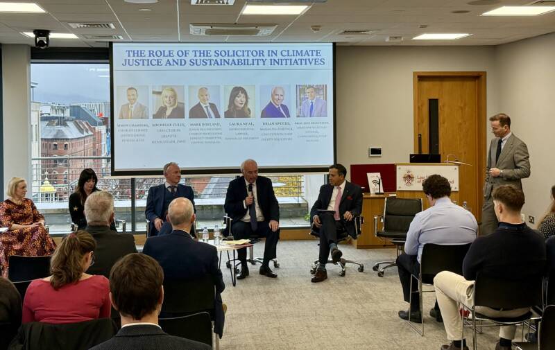 Panel members sit in front of an audience