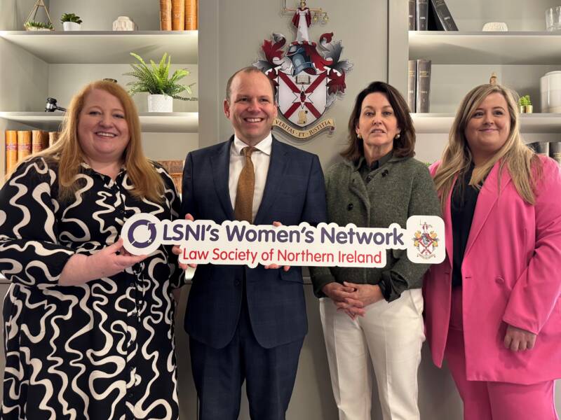 Justice Minister Naomi Long, LSNI President Colin Mitchell, Professor Esther McGuiness and Claire McAleer standing holding a Women's Network logo cutout