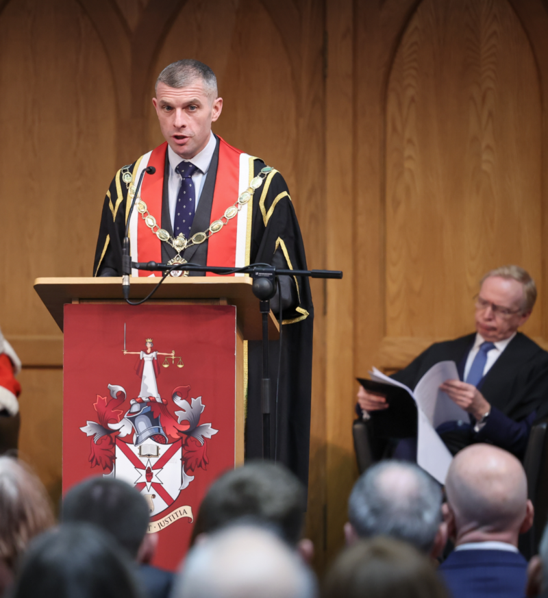 LSNI President Darren Toombs stands at a podium addressing an audience