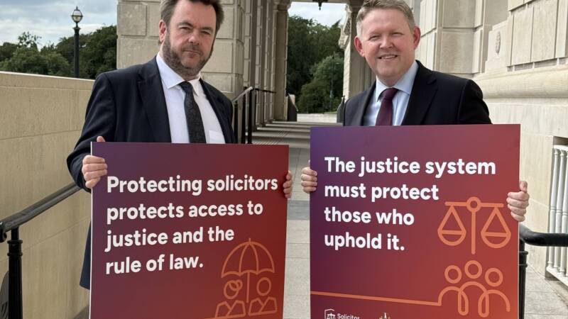 Eoghan McKenna holds a Solicitor Safety poster prior to an appearance before the Justice Committee
