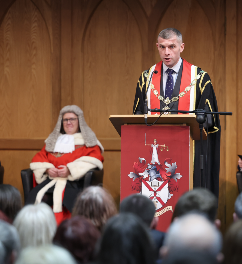 LSNI President Darren Toombs stands at a podium addressing an audience