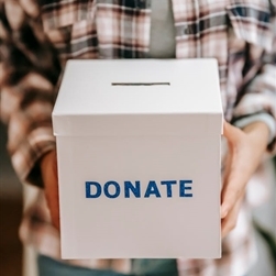 A person's hands holding a donation box