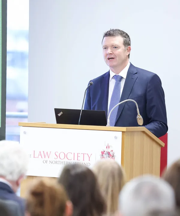 LSNI speaker stands at a podium addressing an audience